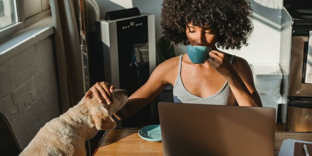 강아지를 만지며 커피를 마시는 여성